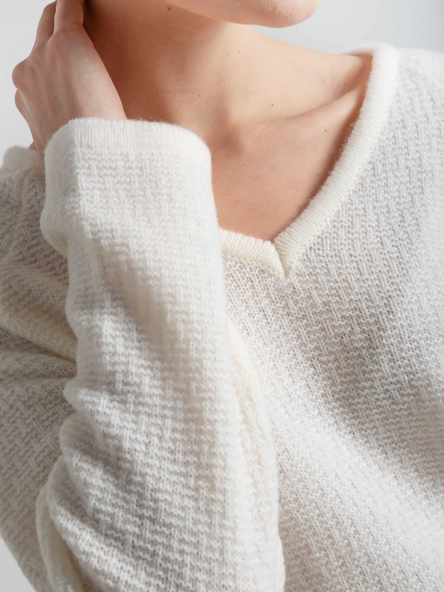Sweter ESSENTIAL V-neck No 1 śmietankowa biel - rękaw Sweter z merynosa biały ESSENTIAL V-neck No 1 - zbliżenie na rękaw i dekolt
