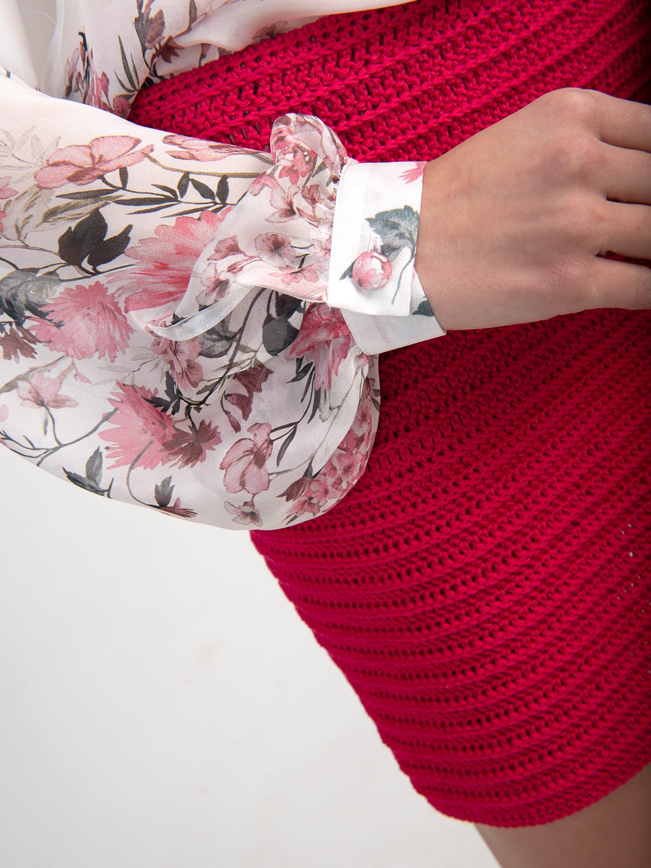 Jedwabno-bawełniana bluzka z falbaną LIMITED EDITION Bluzka z jedwabiu i bawełny z kwiatowym nadrukiem z limitowanej kolekcji z guzikiem na mankiecie i bufiastymi rękawami na tle czerwonej szydełkowej spódnicy