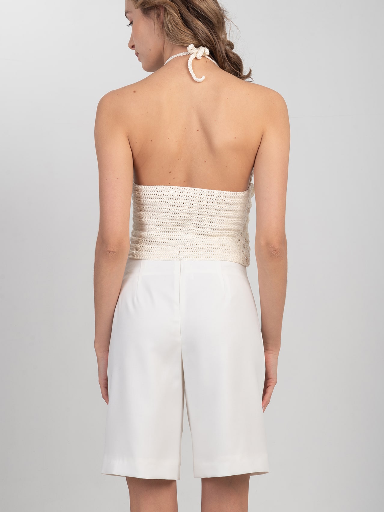 Wełniane szorty w śmietankowej bieli Białe wełniane szorty zestawione z szydełkowym topem - widok z tyłu