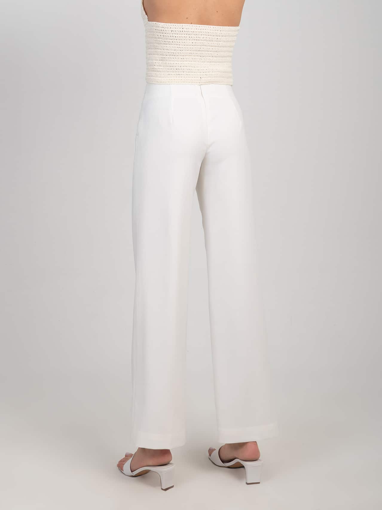 Wełniane klasyczne spodnie w śmietankowej bieli Damskie wełniane klasyczne spodnie od garnituru w bieli zestawione z białymi klapkami na obcasie - widok z tyłu